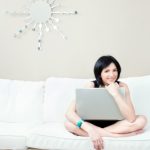 Girl On White Sofa With Laptop